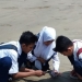 Tampak tiga orang siswa SMPN 2 Malingping tengah mengerjakan riset ubur-ubur di pantai Bagedur untuk final Olimpiade Penelitian Siswa Indonesia di tingkat nasional.