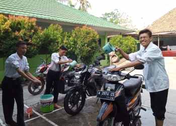 Siswa MA Al-Khairiyah Pipitan saat membersihkan kendaraan guru dalam rangka memperingati Hari Guru Nasional, Senin (25/11).