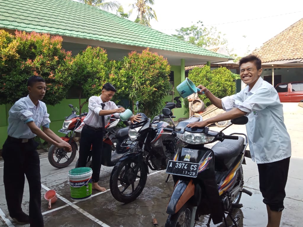 Siswa MA Al-Khairiyah Pipitan saat membersihkan kendaraan guru dalam rangka memperingati Hari Guru Nasional, Senin (25/11).