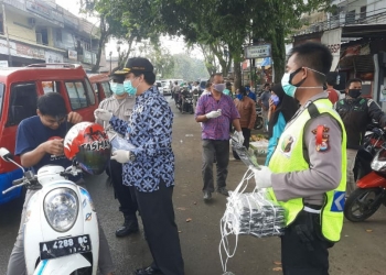 Asda III Setda Lebak, Feby Hardian saat membagikan masker kepada pengendara sepeda motor.