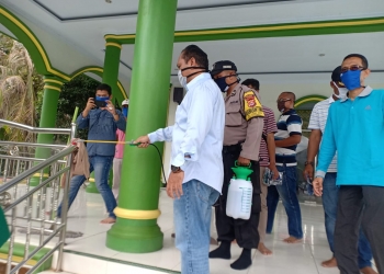Wakil Ketua DPRD Kota Cilegon (berkemeja panjang), Sokhidin, didampingi Lurah Halil menyempatkan diri melakukan penyemprotan Desinfektan di Masjid Baitussalam Lebakdenok Tower, Kecamatan Citangkil, Jumat (3/3).