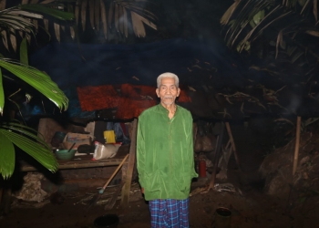 Kakek Sanian saat di depan rumahnya yang kondisinya nyaris roboh.