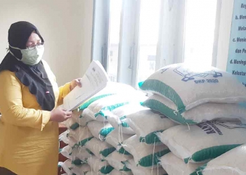 Kasi Kesejahteraan Sosial (Kesos) pada Kelurahan Cipocok Jaya, Murdiatun, saat menghitung sisa sembako jaring pengaman sosial (JPS).