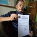 Saudagar beras asal Pandeglang, H Ating Saefudin saat memperlihatkan surat keterangan dari KUA Menes.