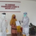 Pasien 03 berinisial HM warga Kota Cilegon saat menerima selembar surat yang dipastikan keterangan sembuh dari salah seorang dokter di RS Darurat Penanganan Covid-19 Wisma Atlet, Selasa (26/5).// Istimewa