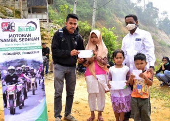Laz Harfa bersama Komunitas Supermoto Pandeglang Chapter , saat memberikan bantuan ke masyarakat di kawasan negeri di atas awan / ISTIMEWA
