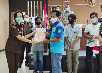 Kajari Kota Cilegon, Ely Kusumastuti didampingi Kasi Pidum, M Ikbal Hadjarati saat menyerahkan Surat Penghentian Penuntutan kepada Jamaludin, tersangka laka lantas di Kantor Kejari Cilegon, Jumat (12/3/2021).