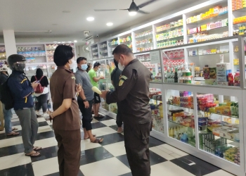 Jajaran Kejari Cilegon saat memberikan imbauan soal harga obat dan membagikan stiker terkait aturan sanksi tipiring PPKM Darurat di salah satu apotek di Kota Cilegon, Rabu (7/7).