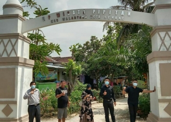 Lurah Pipitan, Tuti, saat berfoto bersama di gapura pintu masuk Kampung Wisata di Kelurahan Pipitan, Kecamatan Walantaka, Kota Serang.