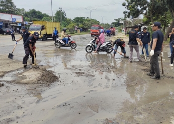 Dishub, DPKP Kota Cilegon dan masyarakat saat membersihkan ceceran pasir di JLS Cilegon kilometer 4, Kelurahan Kalitimbang, Kecamatan Cibeber, Kota Cilegon, Rabu (26/1). LUKMAN HAPIDIN/BANTEN POS