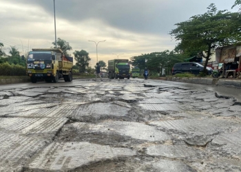 Pengendara saat melintasi kondisi JLS yang rusak parah di kilometer 4, Kamis (27/1). [LUKMAN HAPIDIN/BANTEN POS]