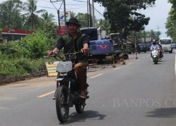 Pengguna jalan saat melintasi ruas jalan Labuan-Panimbang yang sedang dilakukan penggalian pipa.