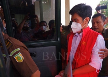 Petugas Kejati Banten menggiring tersangka QAB masuk kedalam mobil tahanan di Kejati Banten, Kota Serang, Kamis (3/2). Kejati Banten melakukan penahanan terhadap tersangka QAB karena diduga telah melakukan pemerasan atau pungli terhadap perusahan jasa titipan di Bandara Soekarno Hatta. [FOTO: DZIKI OKTOMAULIDI/BANTEN POS]