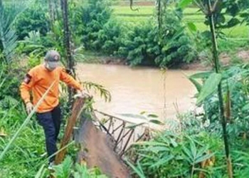 Petugas memperlihatkan jembatan gantung yang putus beberapa waktu yang lalu.