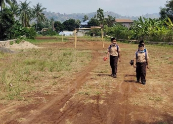 Sejumlah anak sekolah saat melintasi proyek pembangunan JLU yang berlokasi di Kelurahan Purwakarta, Kecamatan Purwakarta Kota Cilegon. [LUKMAN HAPIDIN/BANTEN POS]