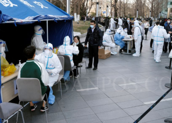 Warga antre untuk tes Covid-19 di sebuah mall di Beijing, China, Senin, 21 Maret 2022. (Foto Reuters/Carlos Garcia Rawlins)