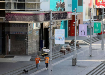 Beberapa orang berjalan melewati toko-toko di kawasan Huaqiangbei, pasar elektronik terbesar di dunia di Shenzhen, Provinsi Guangdong, China, 14 Maret 2022. (Foto Foto Chinatopix Via AP)