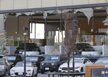 Kaca jendela dari sebuah toko penjualan mobil pecah usai digoyang gempa bumi di Koriyama, Prefektur Fukushima, Jepang, Kamis (17/3). (Foto Kyodo via Reuters)