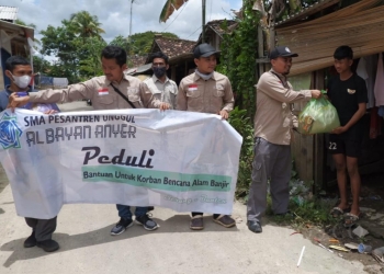 Kepala Sekolah SMA Pesantren Unggul Al Bayan Anyer, Deden Ramdani beserta jajaran memberikan bantuan berupa sembako kepada warga yang terdampak bencana banjir di Kampung Sukajaya, Kota Serang, Selasa (8/3). DZIKI OKTOMAULIYADI / BANTEN POS