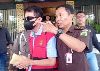 Tersangka Korupsi Bank Banten berinisial DWS saat digelandang oleh penyidik Kejati Banten dari dalam gedung Kejati Banten menuju ke mobil tahanan, Selasa (21/3).