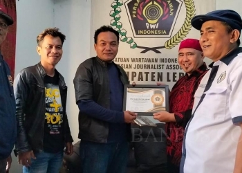 Ketua PWI Kabupaten Tangerang Sri Mulya dan Ketua PWI Lebak Fahdi Khalid bertukar cinderamata.