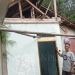 Salah satu warga korban pergerakan tanah merobohkan rumahnya yang telah rusak berat.