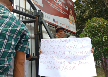 Massa aksi saat membentangkan poster tuntutan dalam aksi di depan kantor Dindikbud Provinsi Banten, Senin (31/7). (Dziki Oktomulyadi/Banten Pos)