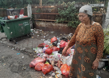 Seorang perempuan menunjukkan lokasi jasad pemulung yang meninggal. EKO SETIAWAN/SATELIT NEWS.COM