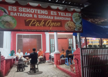 Penggemar Siomay dan Es Sekoteng Pak Oyen tengah mendengarkan musik usai menikmati santapan makanan dan minuman segar di kedai tersebut.