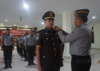 Kalapas Kelas IIA Cilegon, Enjat Lukmanul Hakim menyematkan tanda kenaikan pangkat kepada satu pegawai fungsional Lapas Kelas IIA Cilegon, pada senin (23/10).