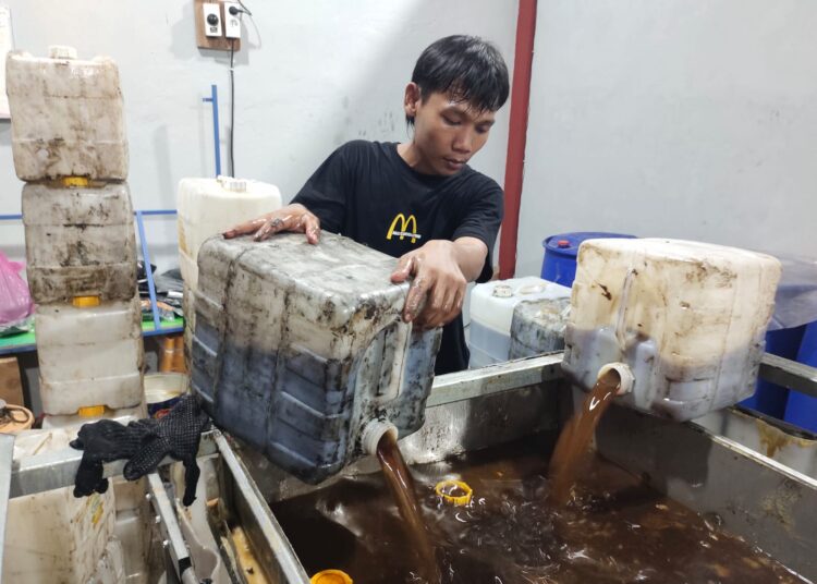Muhammad Idrus Jamalulen (25) saat menuangkan minyak jelantah untuk diolah menjadi biodiesel di gudang TUKR x Minyaku di IPST ASARI Lingkungan Serdag, Kelurahan Kotabumi, Kecamatan Purwakarta, Kota Cilegon, Senin (2/6/2025). LUKMAN HAPIDIN/BANTEN POS