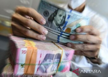 Petugas menjunjukkan uang pecahan dolar AS dan rupiah di gerai penukaran mata uang asing di Jakarta, Kamis (15/5/2025). ANTARA FOTO/Muhammad Adimaja/bar/aa.